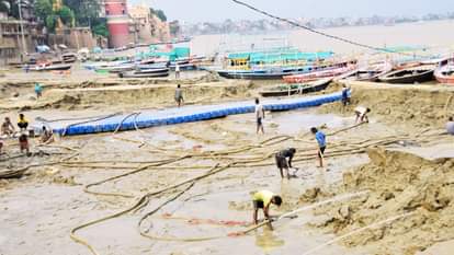 घाट पर जमी सिल्ट की सफाई करते कर्मचारी।