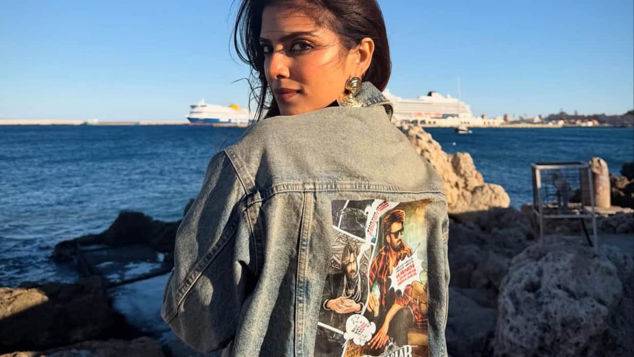 malavika mohanan wear jacket with the poster of horror comedy film the raja saab in greece