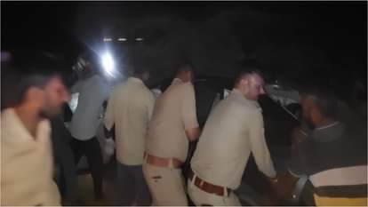 कार से युवक को निकालने का प्रयास करते पुलिसकर्मी