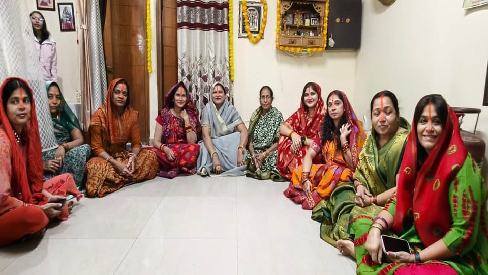 Women observing fast offer prayers to the setting sun