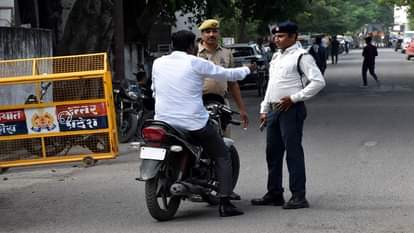 पुलिस लाइन के गेट पर बाइक सवार बिना हेलमेट के अन्दर जा रहे बाइक सवार को रोकते पुलिसकर्मी