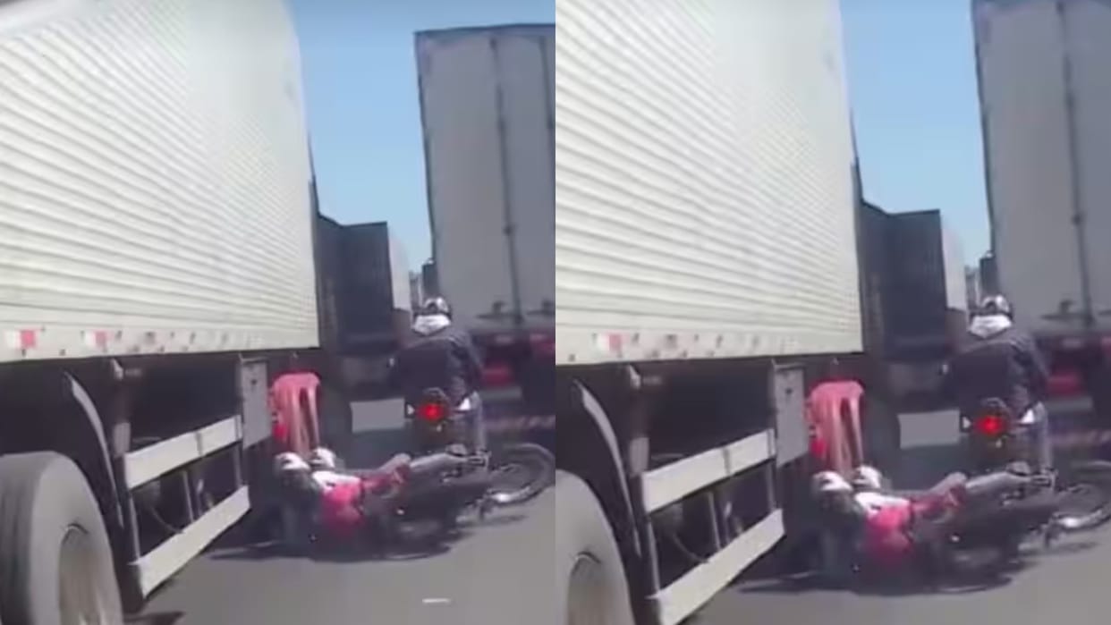 Biker tries to get out of traffic loses balance and woman narrowly escapes being run over by tyre