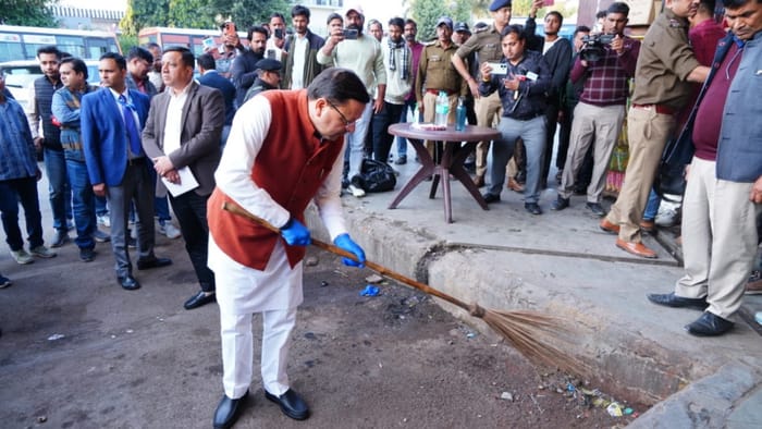 CM Dhami Surprise inspection at ISBT Dehradun angry to see garbage cleaned it himself with a broom