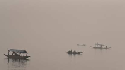 Shikaras were seen moving amidst the morning fog at the famous Dal Lake.
