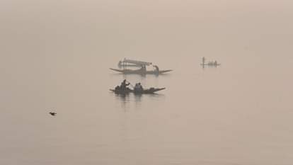 Shikaras were seen moving amidst the morning fog at the famous Dal Lake.