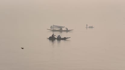 Shikaras were seen moving amidst the morning fog at the famous Dal Lake.
