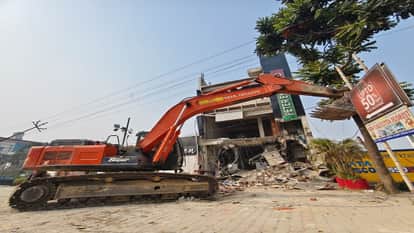 शोरूम को तोड़ने में लगाई गई पोकलेन मशीन