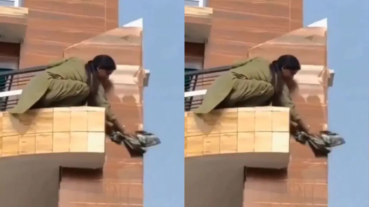 A woman was cleaning the edge of the balcony by holding the grill people were shocked Video goes Viral