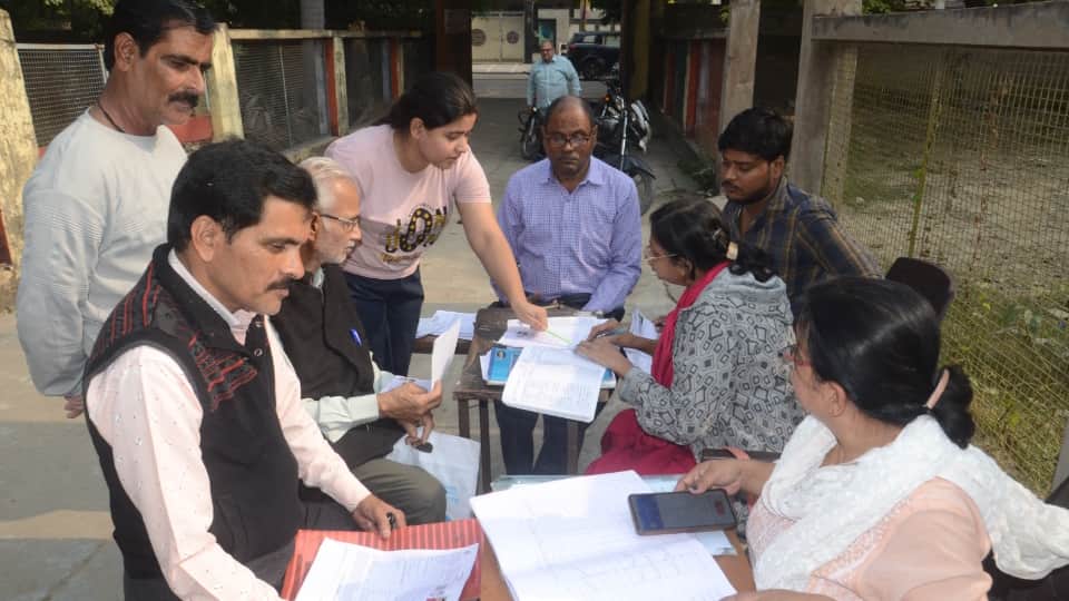 स्कूल में वोटर लिस्ट की जानकारी लेते लोग