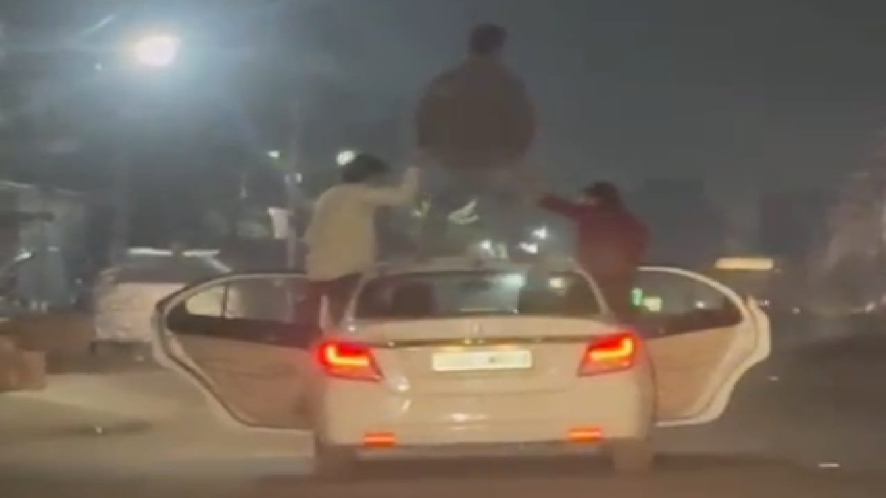 चलती कार पर स्टंट करते युवक