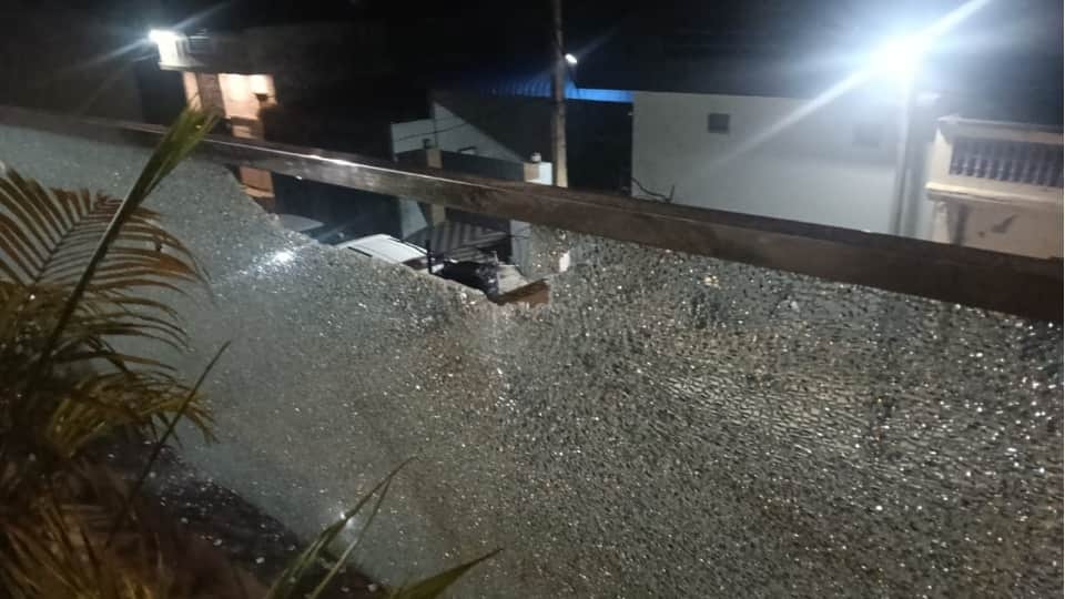 गोलियों से टूटा घर का शीशा।