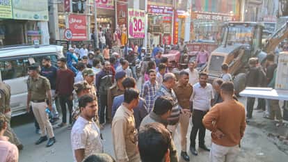 अवैध अतिक्रमण के दौरान सड़क मौजूद स्थानीय लोग और पुलिस टीम।