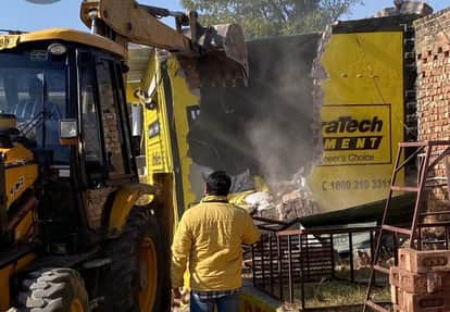 बन तालाब में अवैध ढांचे को जेसीबी से हटाती नगर निगम की टीम।