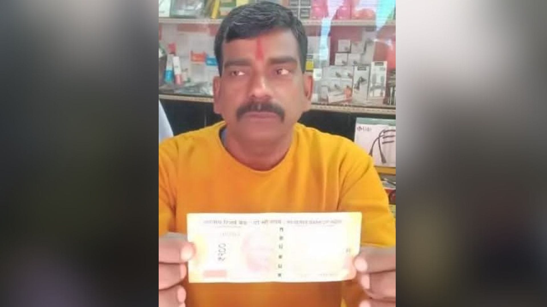 जाली नोट दिखाता दुकानदार