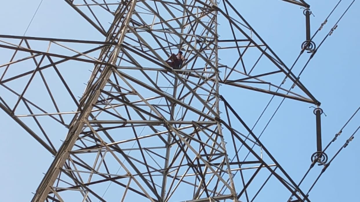 Auraiya angry young man climbed onto high tension tower police and family members persuaded him to come down