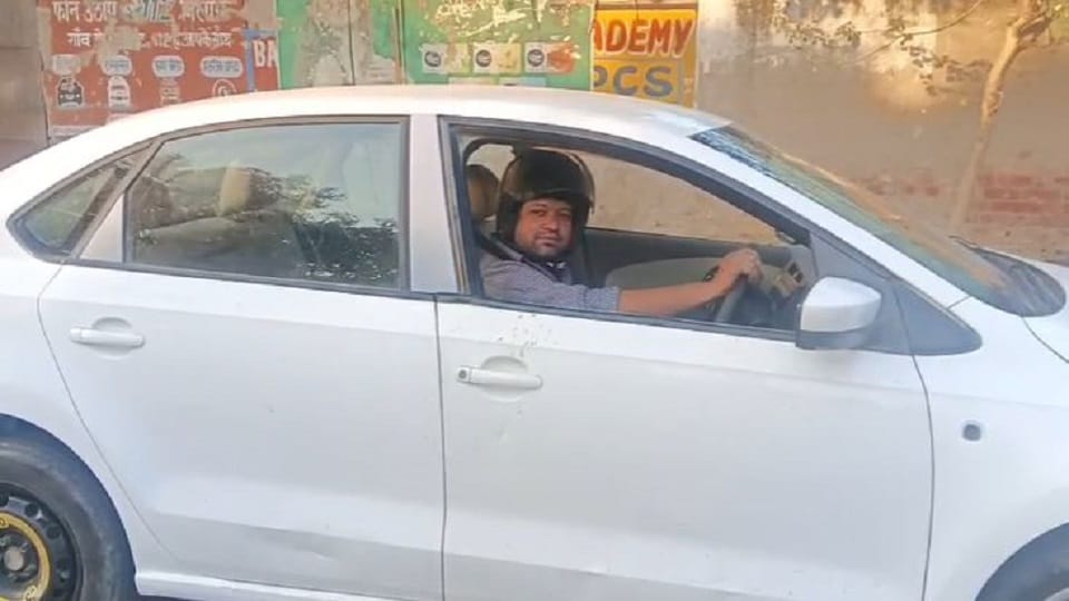 School owner driving car wearing helmet in Agra