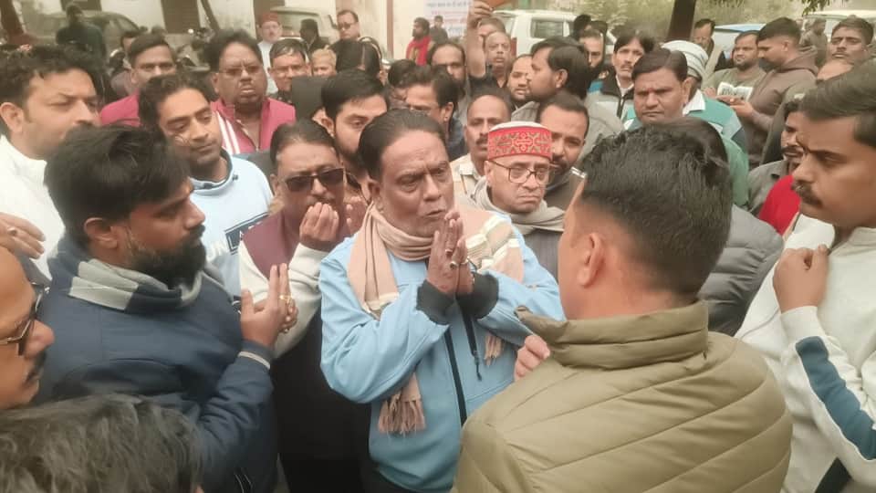 थाने में पुलिसकर्मी से बात करते व्यापारी