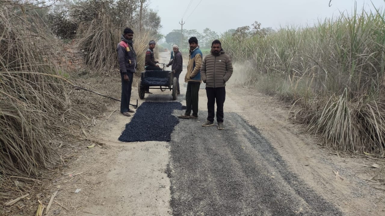 सड़क पर पैचिंग करते कर्मचारी