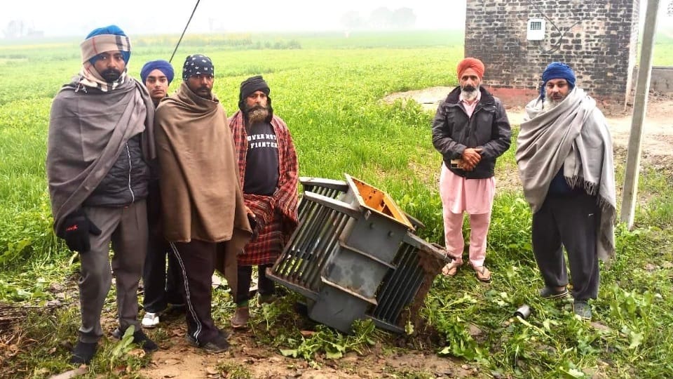ट्रांसफार्मर का खाली खोल दिखाते किसान