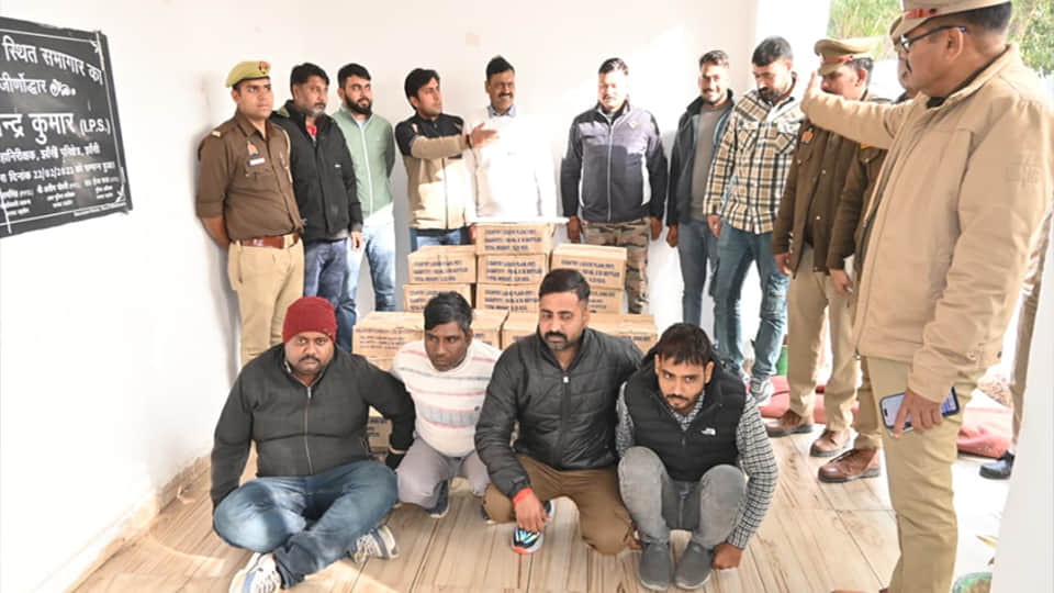 पुलिस गिरफ्त में जमीन पर बैठे आरोपी