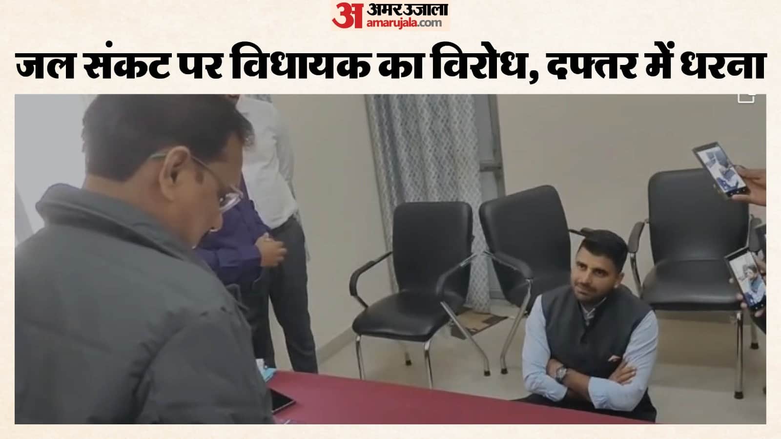 विधायक रविंद्र भाटी जमीन पर बैठकर अधिकारियों से बात करते हुए।