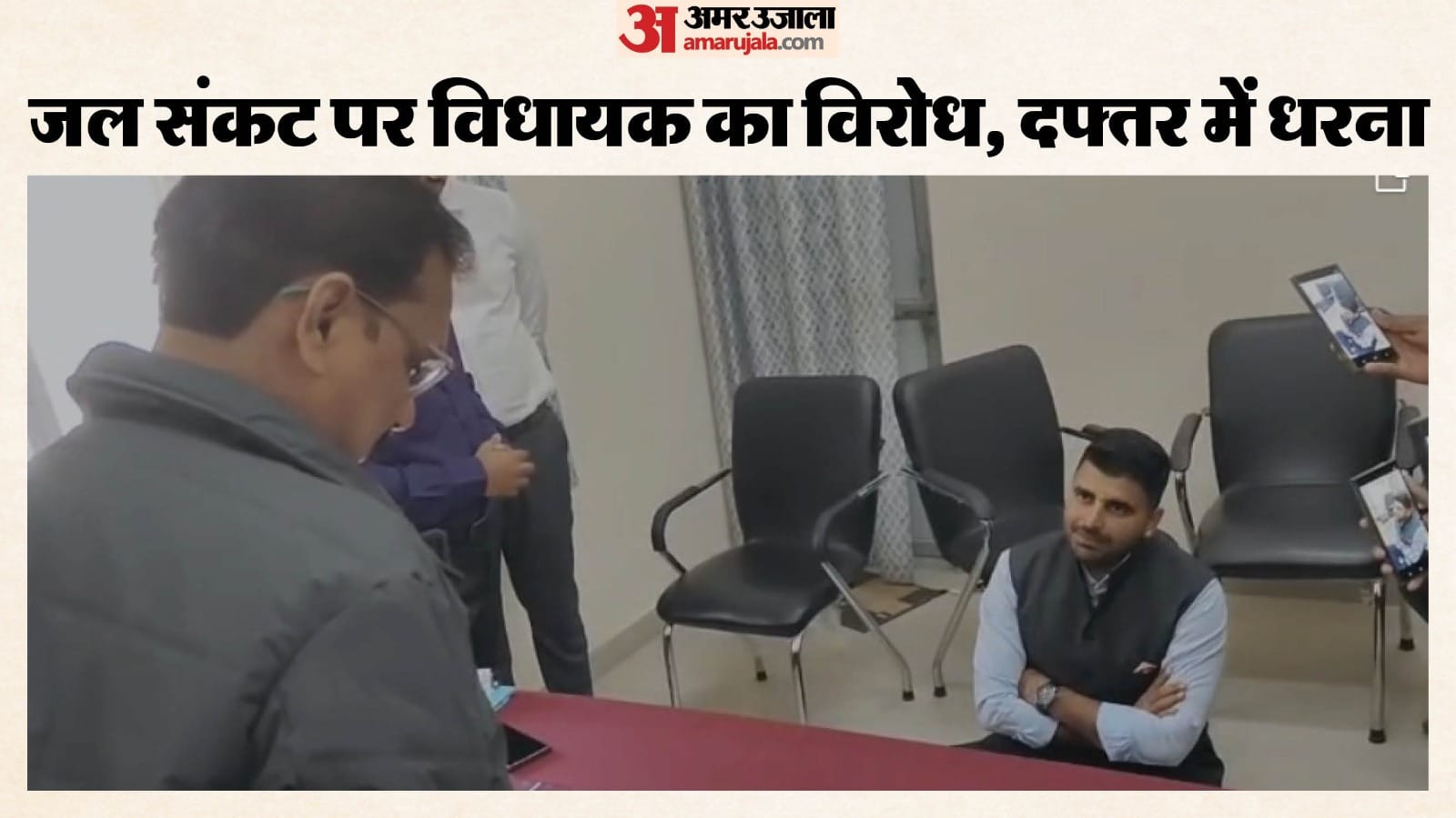 विधायक रविंद्र भाटी जमीन पर बैठकर अधिकारियों से बात करते हुए।