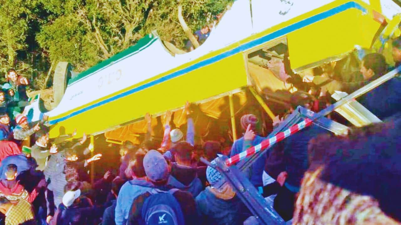 हरिपुरधार में बस को हाथ से उठाकर घायलों को निकालते लोग।