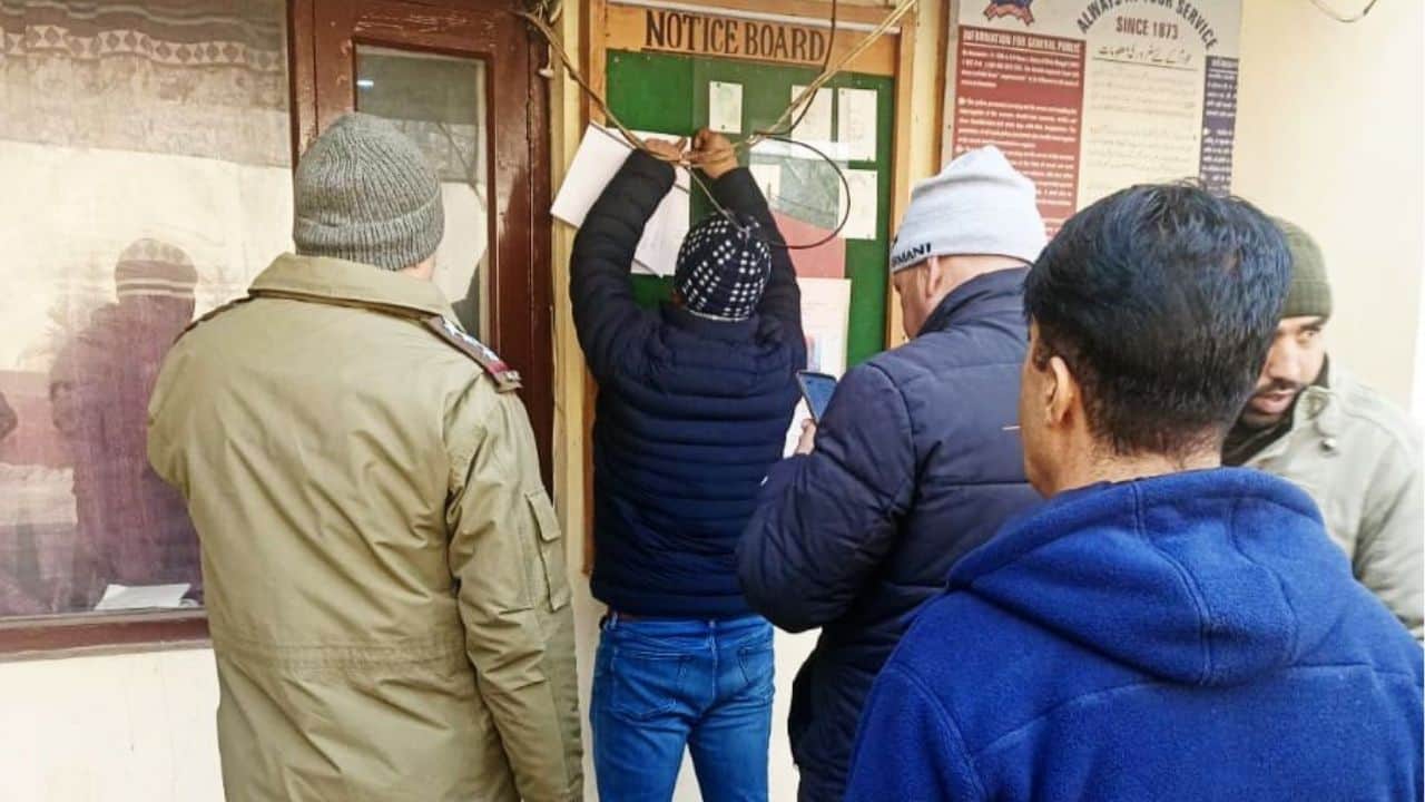 कुपवाड़ा के त्रेगाम में आरोपी के घर पर उद्घोषणा लगाते कर्मी।