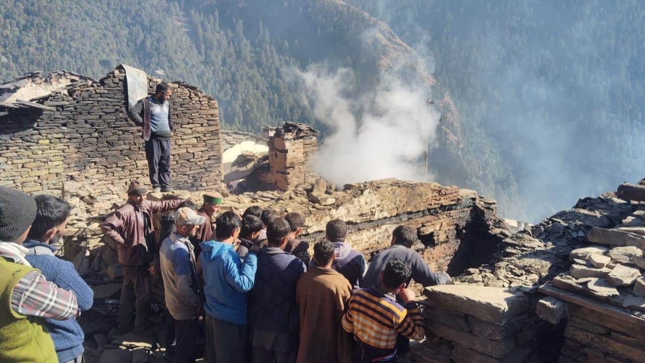 तलांगना में आग लगने के बाद जले मकान से शवों की तलाश करते स्थानीय लोग।