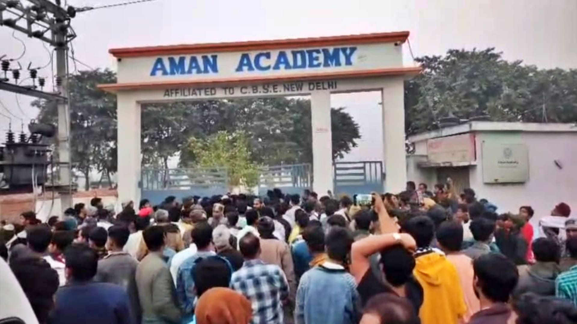 स्कूल के गेट पर हंगामा करते ग्रामीण