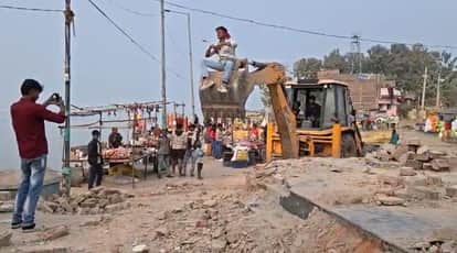 young-man-climbs-on-the-bucket-of-JCB-and-makes-reel-at-the-Umanath-Temple.