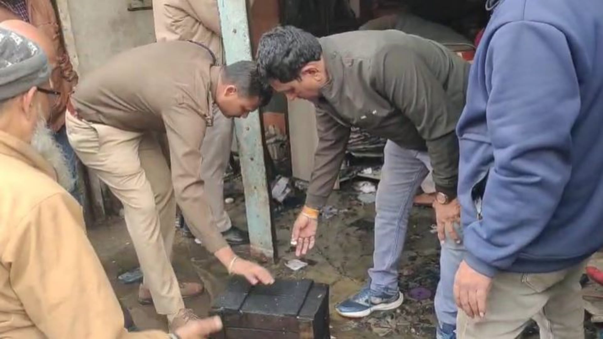 दुकान में जांच करते पुलिस कर्मी