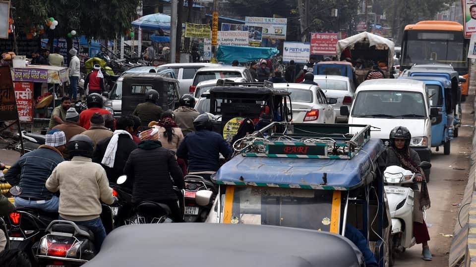 सड़क पर वाहन खड़े होने के कारण लगे जाम में फंसे वाहन व राहगीर