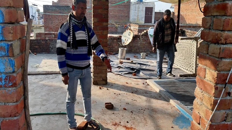 गांव महौ में छत पुर हुए पथराव को दिखाता युवक