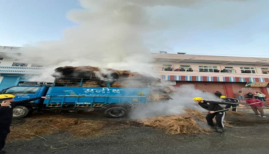 पिथौरागढ़ नगर के रई में कैंटर में भरी सूखी घास में लगी आग को बुझाते फायर सर्विस कर्मी।