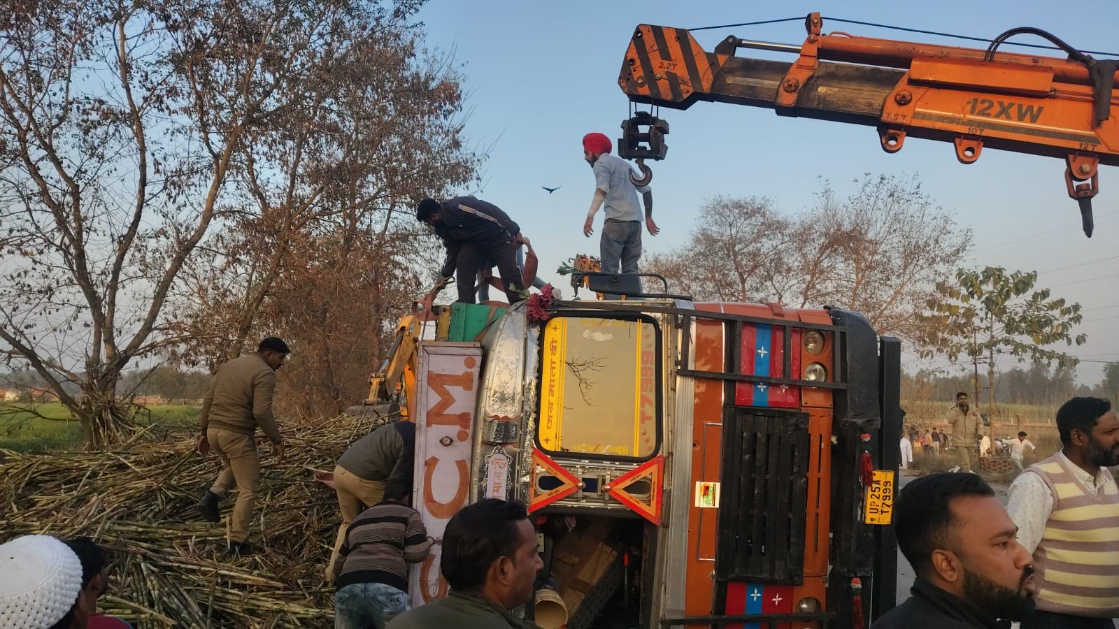 Sugarcane overloaded truck overturns on car police officer recovers safely after an hour