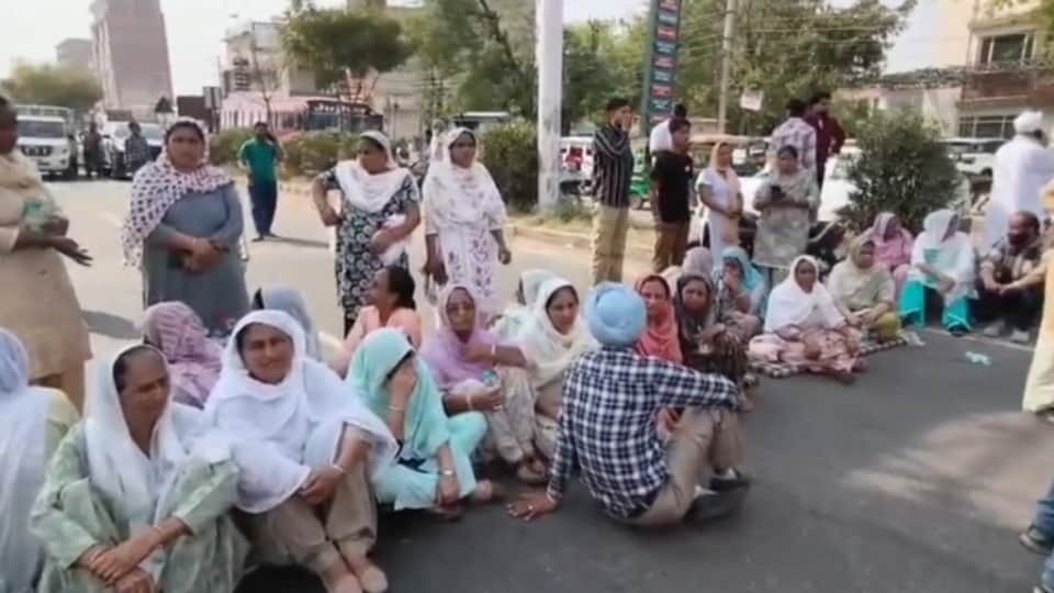 सड़क पर धरना देते मृतका के परिजन।