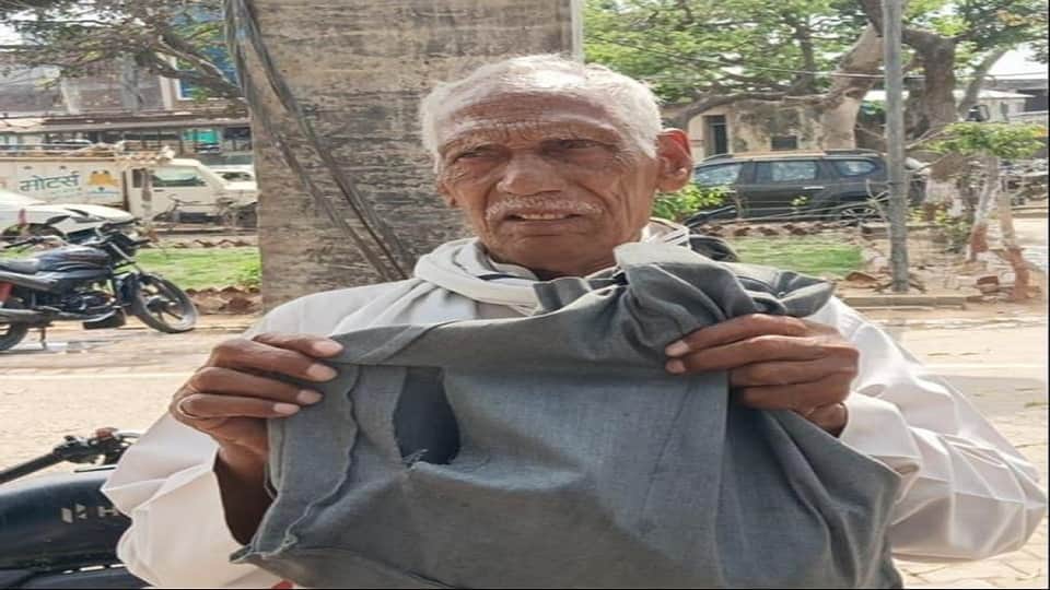 काटे गए थैले को दिखाते बुजुर्ग