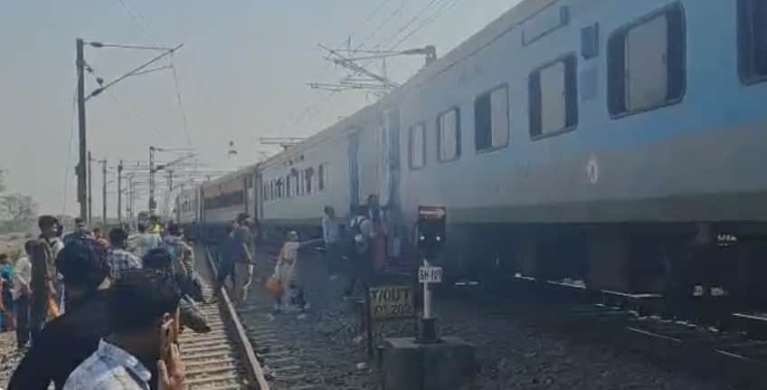 पटरी के बगल में खड़े हुए यात्री।