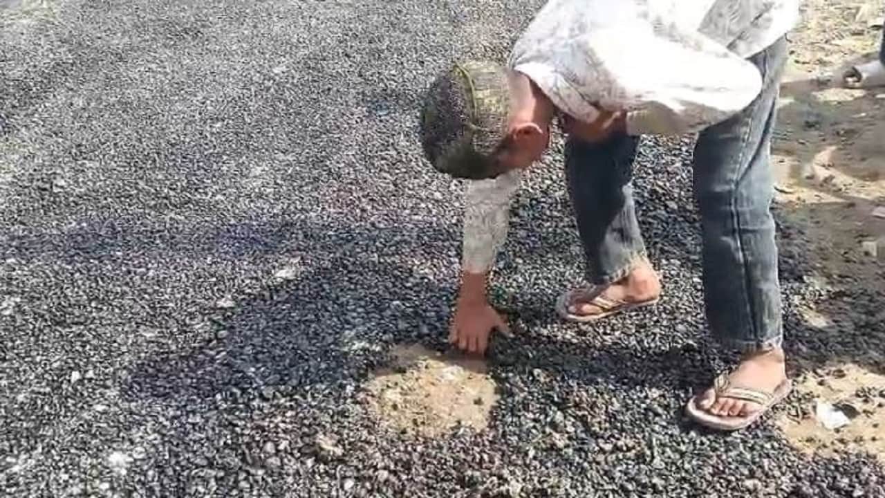 हाथ से सड़क उधेड़ता युवक