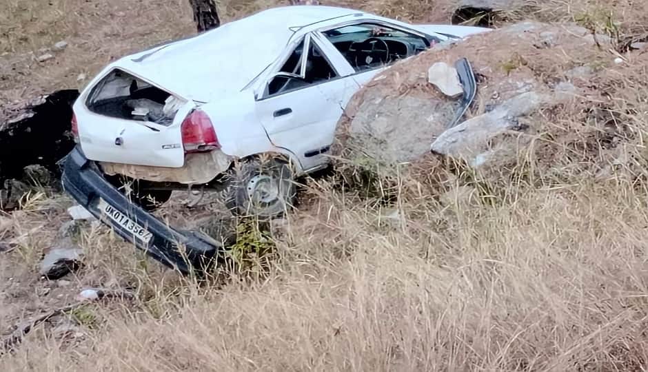 सड़क से नीचे गिरने से क्षतिग्रस्त हुई कार।