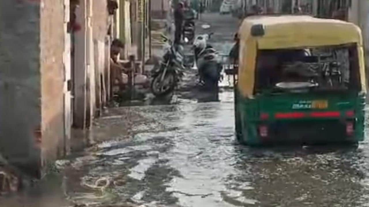 सड़क पर भरे पानी में फंसी टैक्सी।