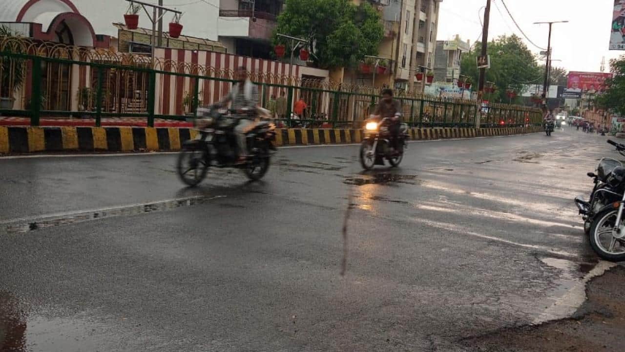 बारिश बंद होते ही सड़क पर निकलता बाइक सवार।