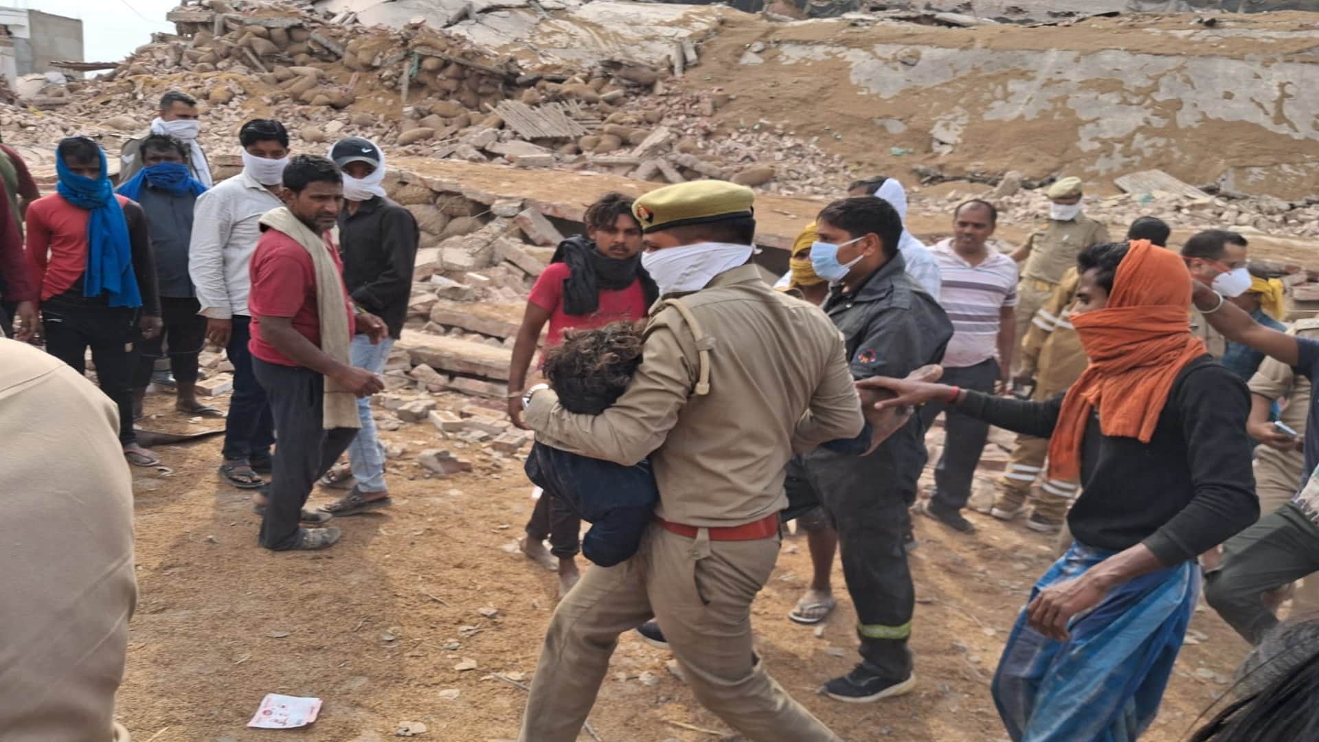 अमोनिया रिसाव के बाद धराशायी हुए मलबे से निकले लोगों को बचाता पुलिसकर्मी।