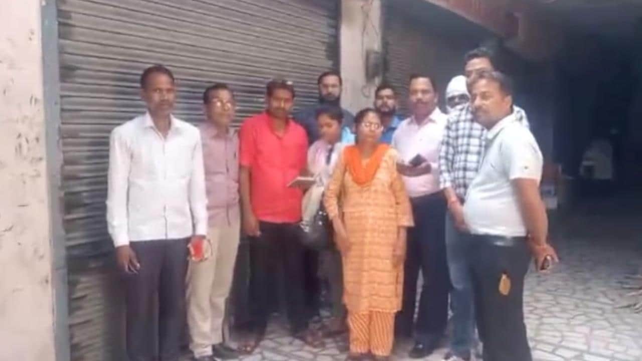 एजेंसी के बाहर सिलिंडर लेने के लिए खड़े लोग।