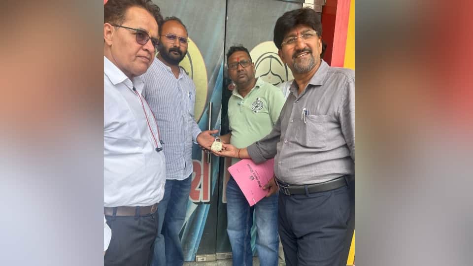 एक होटल पर सील लगाते नगर निगमकर्मी।