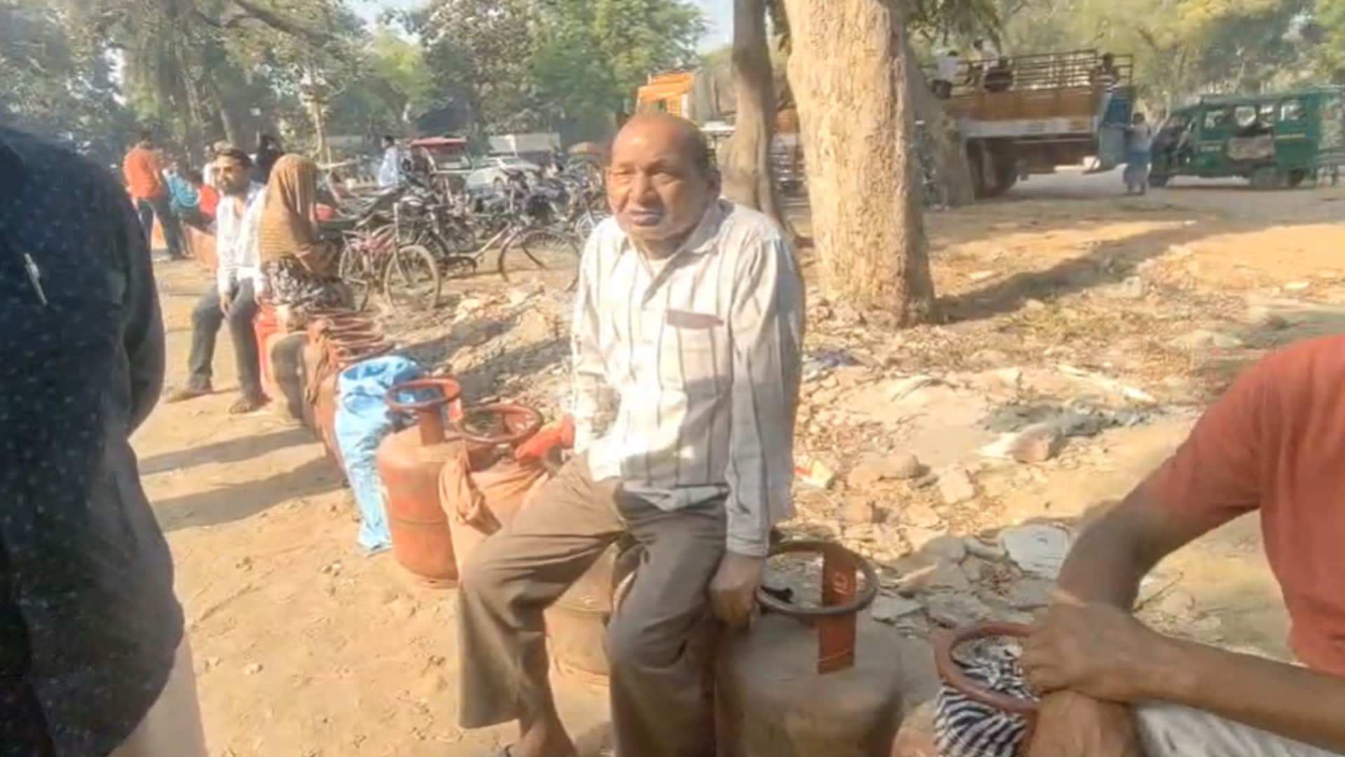 पत्थर गिरजाघर पर गैस सिलेंडर की गाड़ी का इंतजार करते उपभोक्ता।