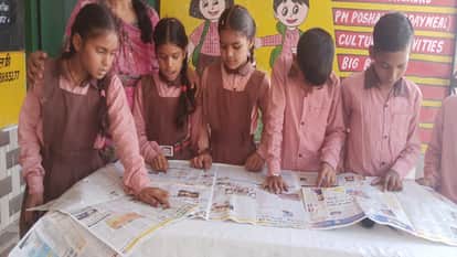 Children read newspapers in schools during the new academic session