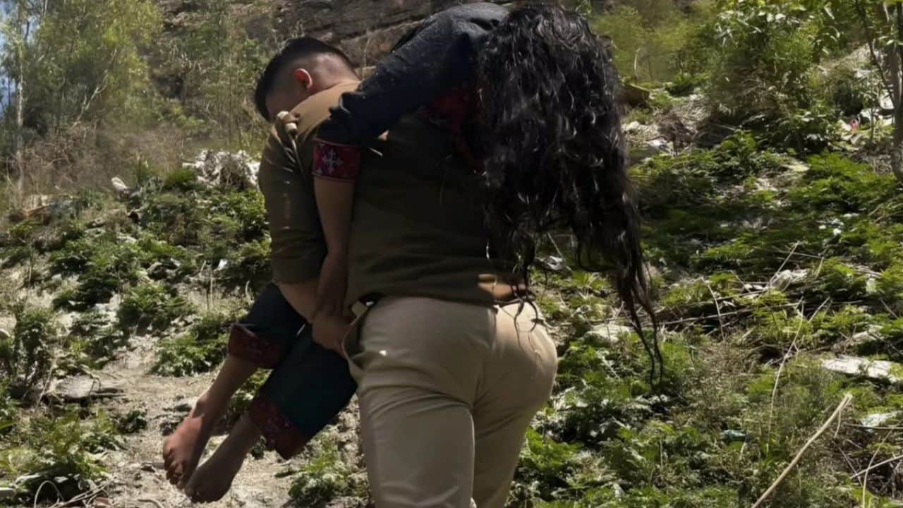 पुलिस जवान महिला को को बचाकर ले जाते हुए।