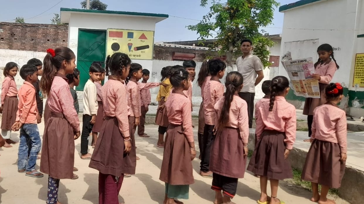 Children read newspapers in schools during the new academic session